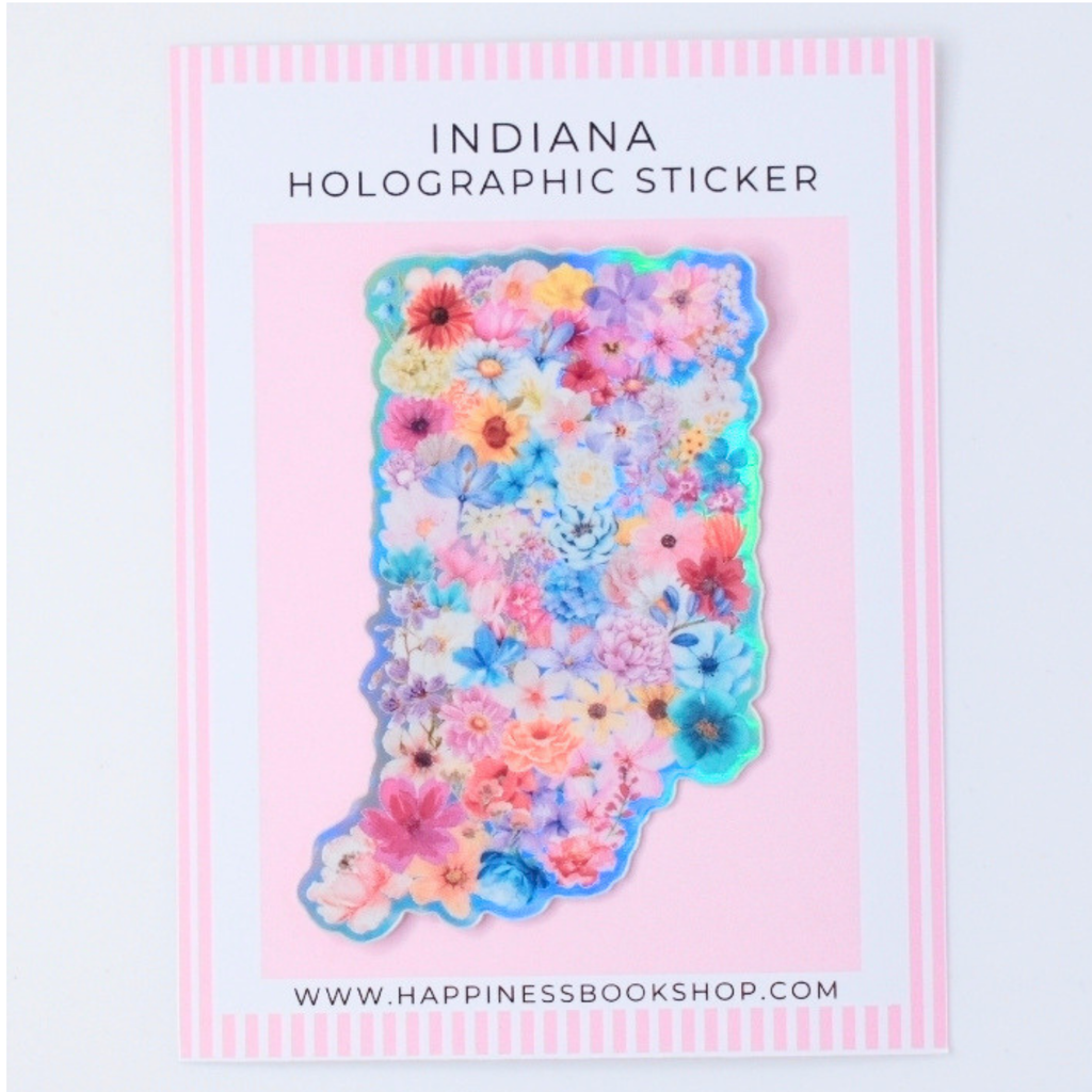 Indiana-shaped holographic sticker covered in colorful pressed flowers, displayed on a pink card with the text 'INDIANA HOLOGRAPHIC STICKER' and the website 'WWW.HAPPINESSBOOKSHOP.